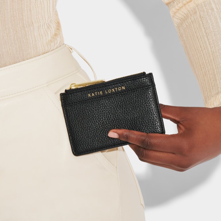 Hand holding a black Katie Loxton mini purse